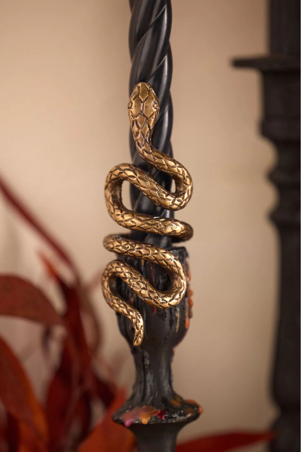 Black twist taper candle holder with a brass snake ornament