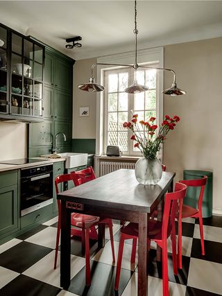 Green kitchen with bold red chairs