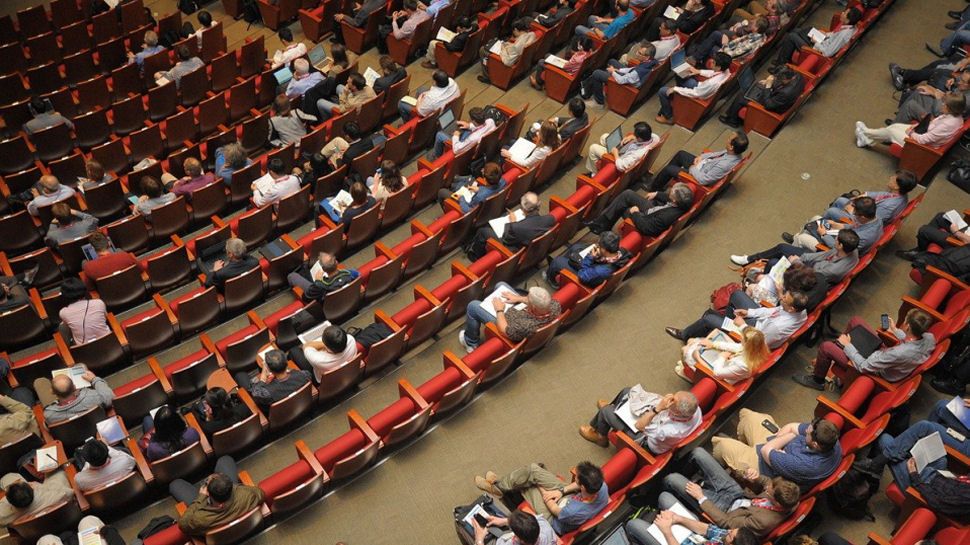 People sat at a conference event.