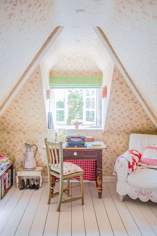 attic bedroom with floral wallpaper and chintz chair