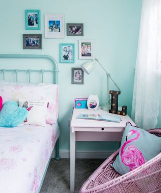 kids bedroom with pink chair and wrought iron bed
