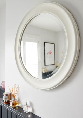 round wall mirror on white wall