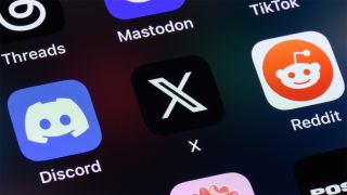 Phone screen showing Discord, X, and Reddit app icons
