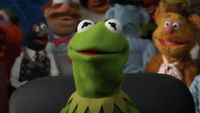 Kermit the Frog sitting in office chair with Gonzo, Fozzie, Swedish Chef and Sam the Eagle behind him in The Muppets