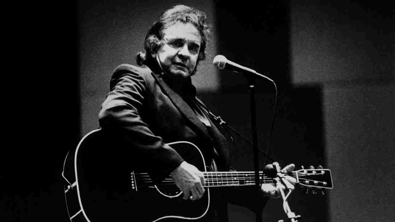 Johnny Cash posing for a photograph with an electric guitar in 1994