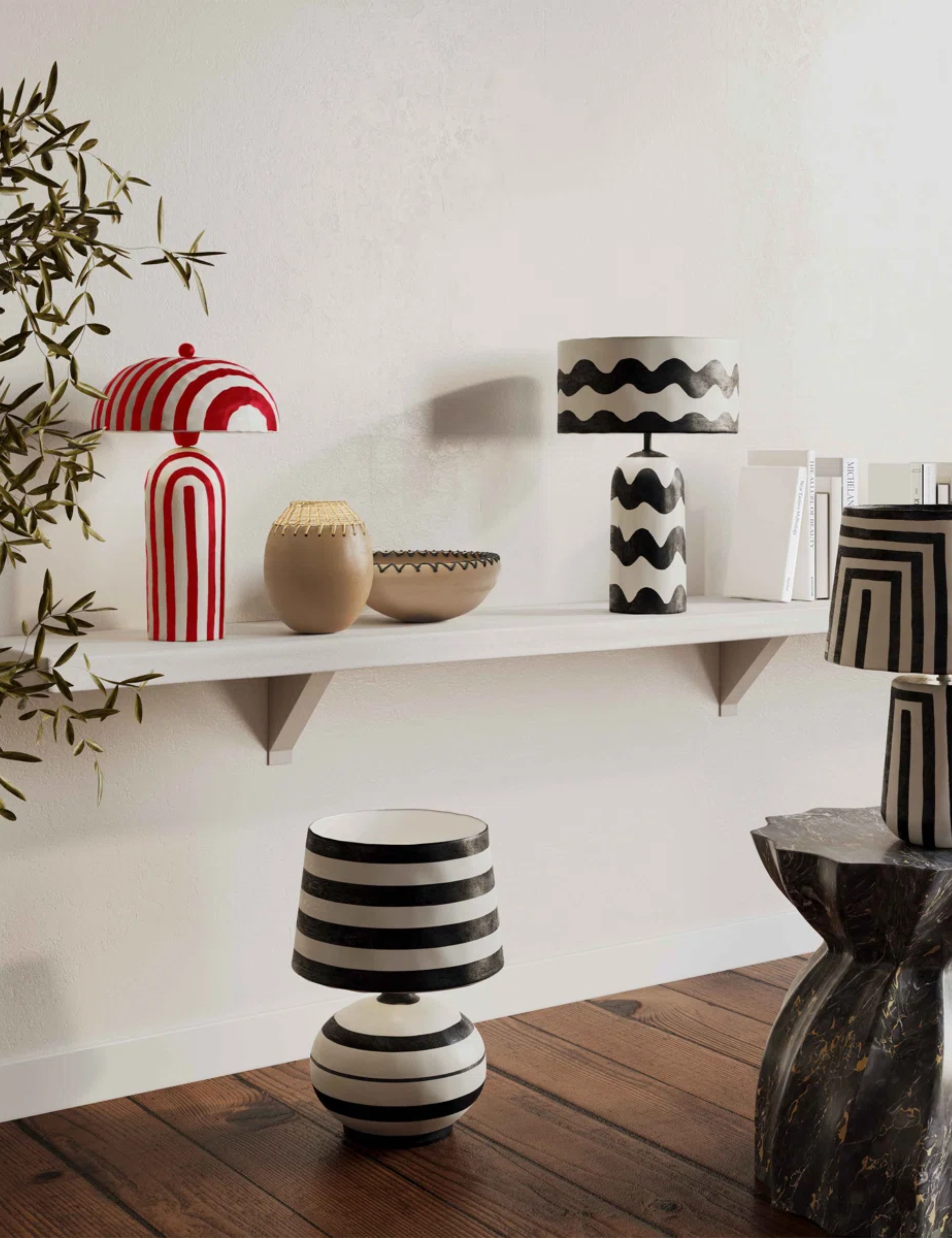 Striped and zig-zag paper mache table lamps in a white-walled interior with wooden floors