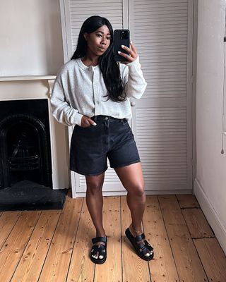 @_loissterling wearing black denim shorts and a cardigan