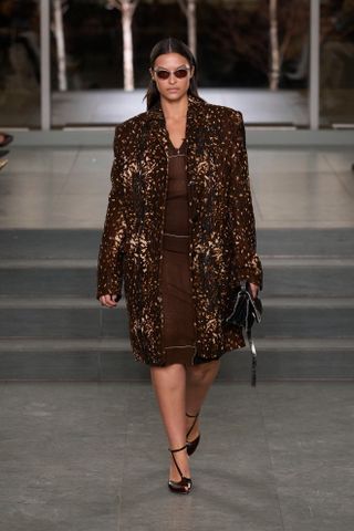 A runway model wears a F/W 2025 Tory Burch outfit.