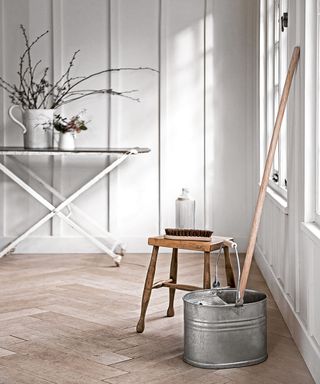 cleaning material with wooden table and modern mop and bucket