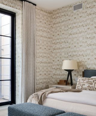 bedroom with white linen and neutral patterned wallpaper