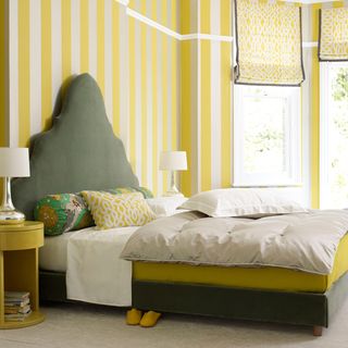 bedroom with stripped yellow wallpaper and headboard