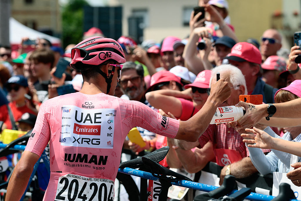 UAE Team Emirates XRG's Mexican rider Isaac Del Toro wearing the pink jersey of overall leader (Maglia Rosa), signs his autograph for the fans ahead the 15th stage of the 108th Giro d'Italia cycling race of 219kms from Fiume Veneto to Asiago on May 25, 2025. (Photo by Luca Bettini / AFP)
