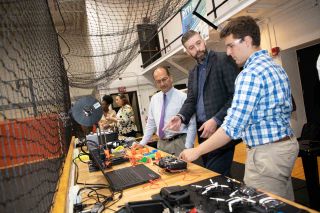 Student Kyle Hirsch, Lecturer Michael Leczinsky, and University President Havidán Rodríguez discussing 3D printing and its application to drone technology in the UAlbany CEHC Drone Lab