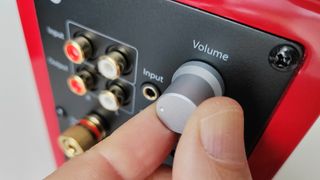 Audioengine A2+ volume dial being turned by a man's hand