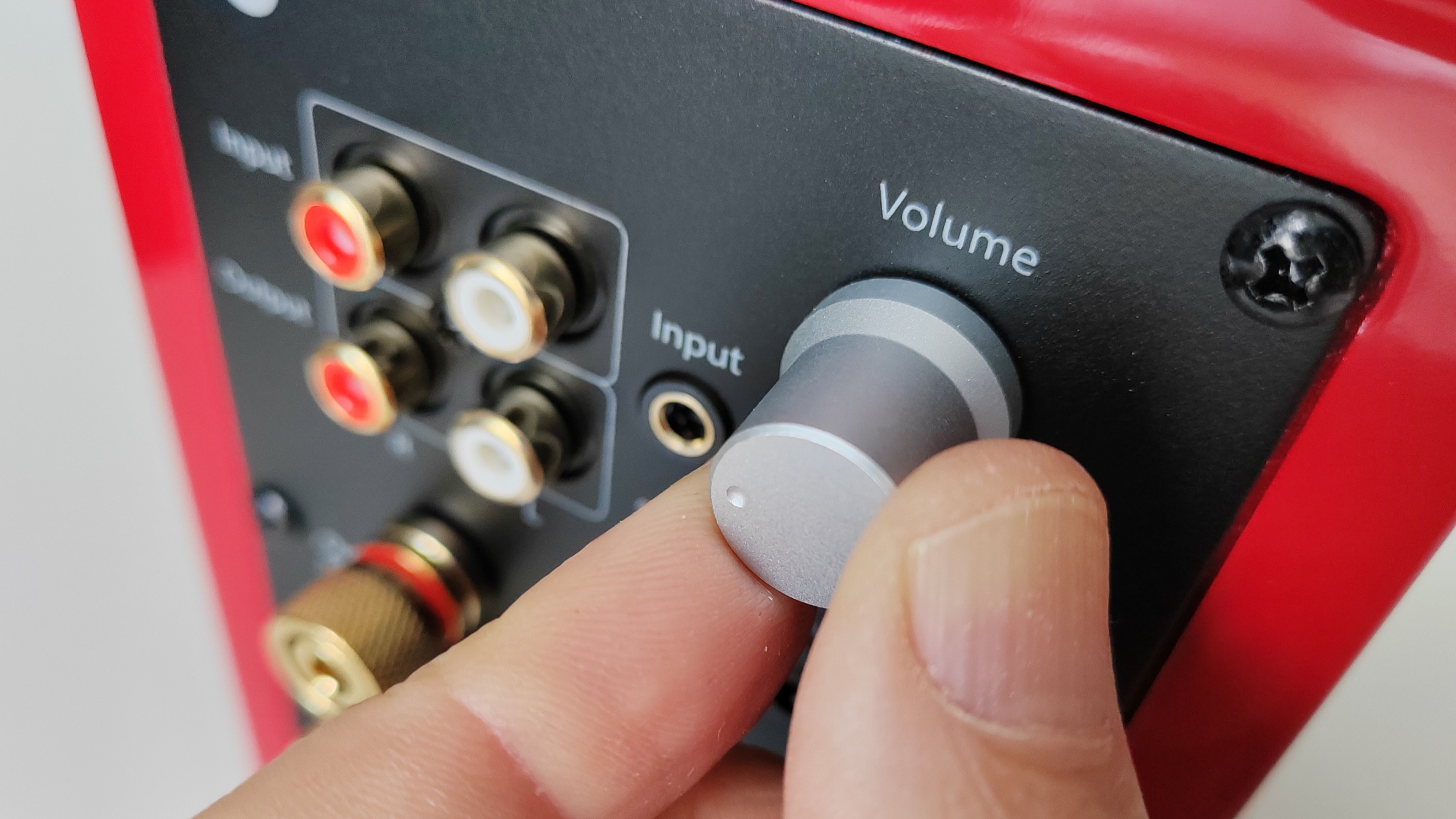 Audioengine A2+ volume dial being turned by a man's hand