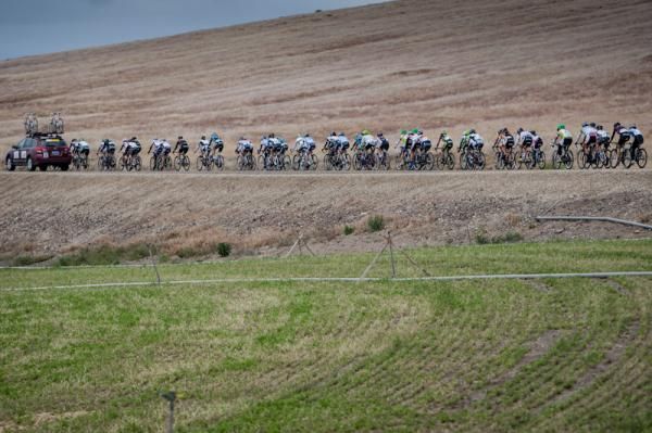 A team car passes the peloton to get up to the break.
