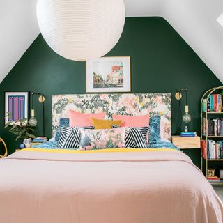 attic bedroom with green wall and pink bedlinen