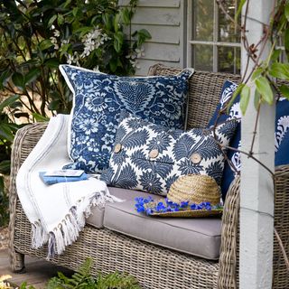 Wicker sofa for neutral cushions and blue and white floral cushions