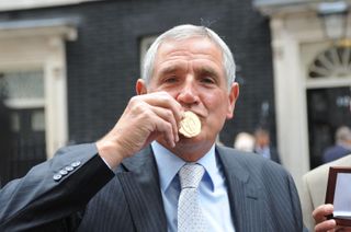Norman Hunter kisses his 1966 World Cup winner's medal, presented to him by Prime Minister Gordon Brown in 2009