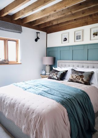 double bedroom with teal panelling and pink bedcovers