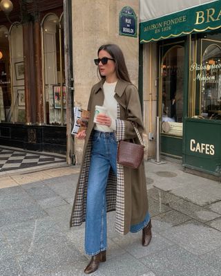 Jeans and boots outfits: @leasy_inparis wears a trench coat with blue jeans and brown boots