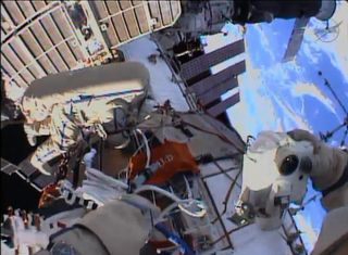The beauty of Earth serves as the backdrop in this helmet camera view from a spacewalk by cosmonauts Alexander Misurkin and Fyodor Yurchikhin (who is visible in frame) as they worked outside the International Space Station on Aug. 22, 2013.