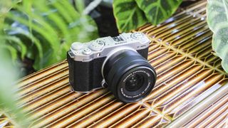 Fujifilm X-M5 on a rustic surface among leaves