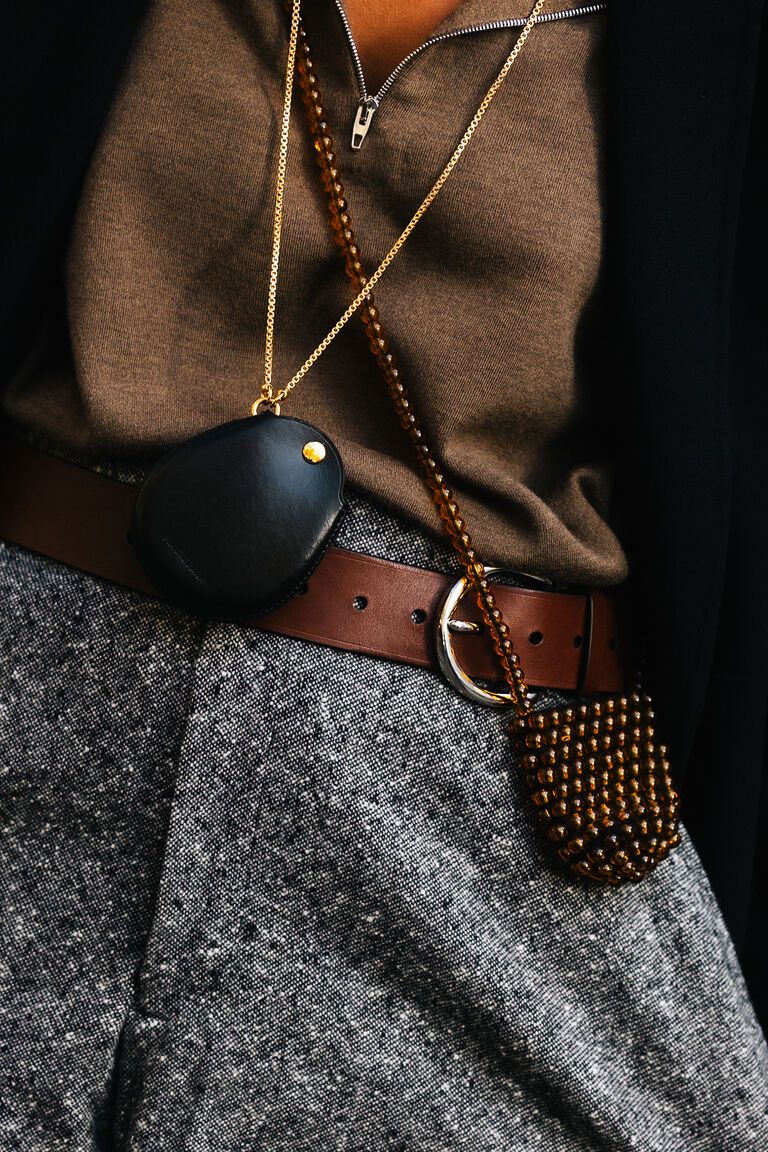 summer 2026 jewelry trends, woman at new york fashion week wearing a black leather case and beaded case pendant necklace 