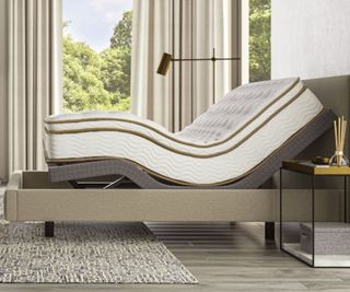 A mattress on the Saatva Adjustable Base Plus against a white wall.