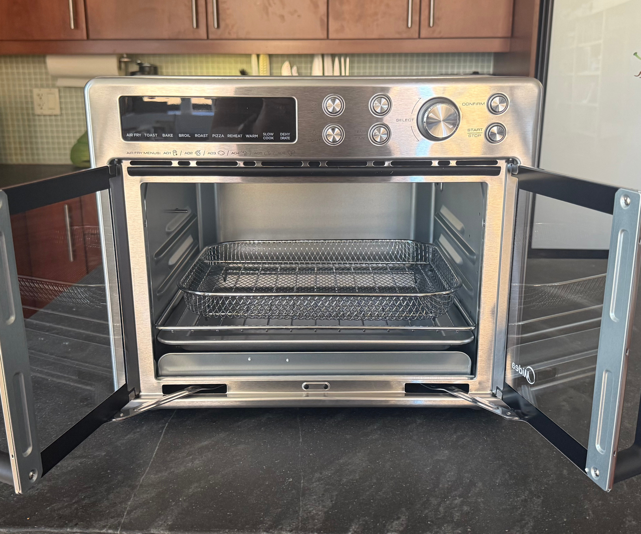 Midea Flexify French Door Air Fryer Oven on a black counter top.