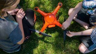 Drones on Amazon: Image shows two people fixing propellers onto drone