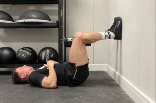 Strength and conditioning coach performing 90/90 Knee Rolls