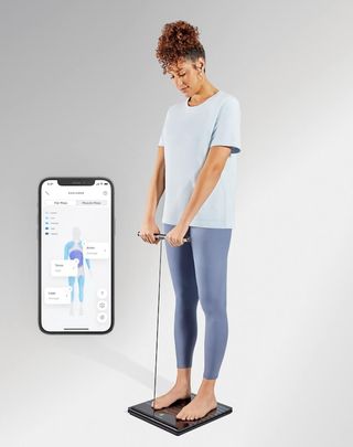 an image of a woman using the Withings Body Scan