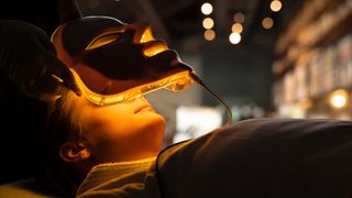 A woman receiving light therapy treatment with an LED mask, one of the at home light therapy for acne treatments