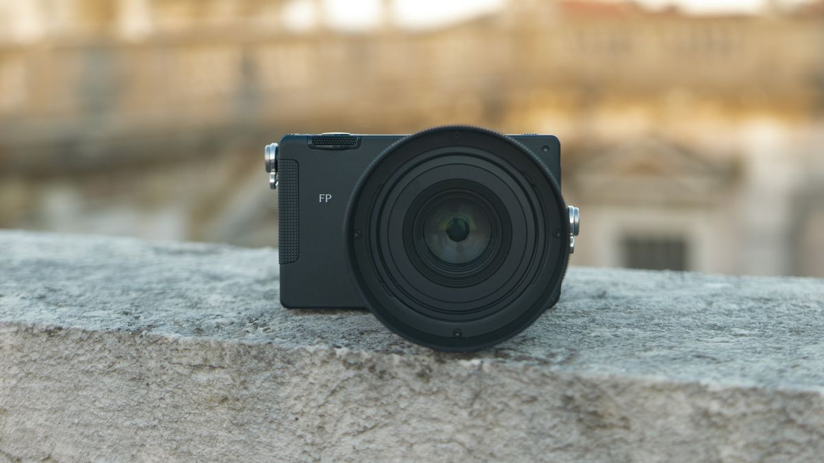 Sigma FP2 mirrorless camera with the 50mm f/2 contemporary lens attached, placed on a marble wall, at golden hour