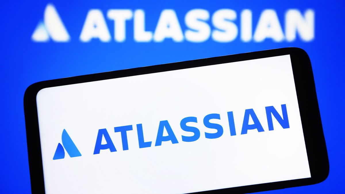 Logo of Atlassian, parent company of workflow platform Trello, pictured on a smartphone with branding in background.