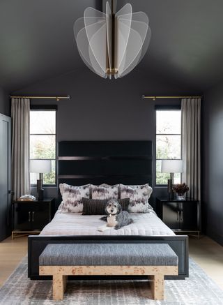a dark grey bedroom with statement lighting