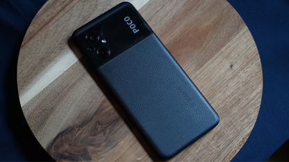 The rear of the Poco M5 smartphone is covered in a black, leather-like material.