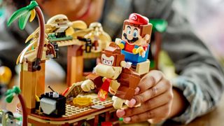 Lego Donkey Kong's Tree House set with Mario on DK's back, being played with by a child