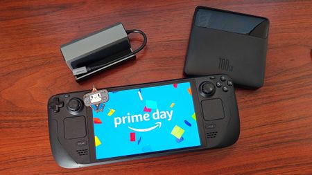 Steam Deck next to Jsaux docking station and Baseus Blade Power Bank with Prime Day logo on screen and Steam Deck mascot keychain on top.