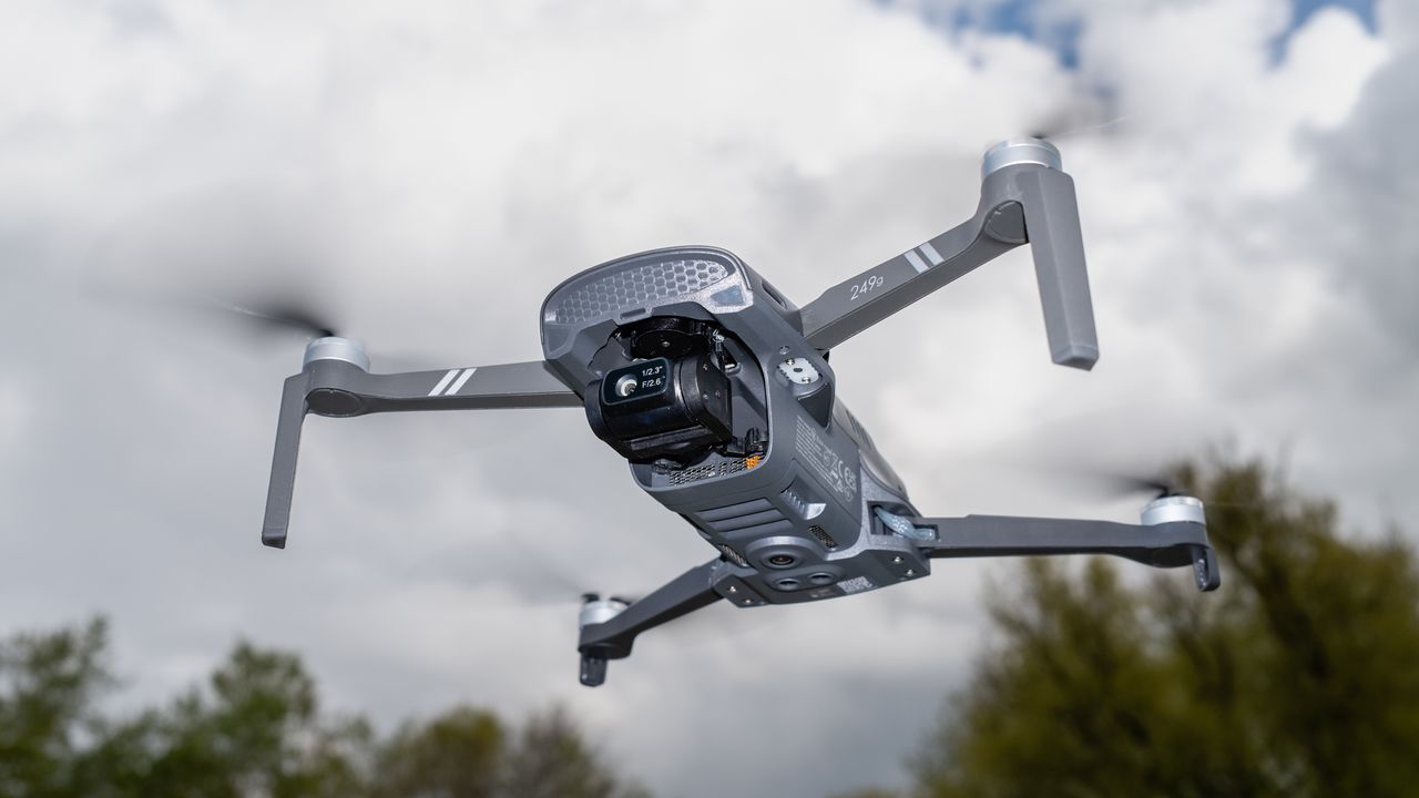 Holy Stone Sirius HS900 in flight against a cloudy blue sky