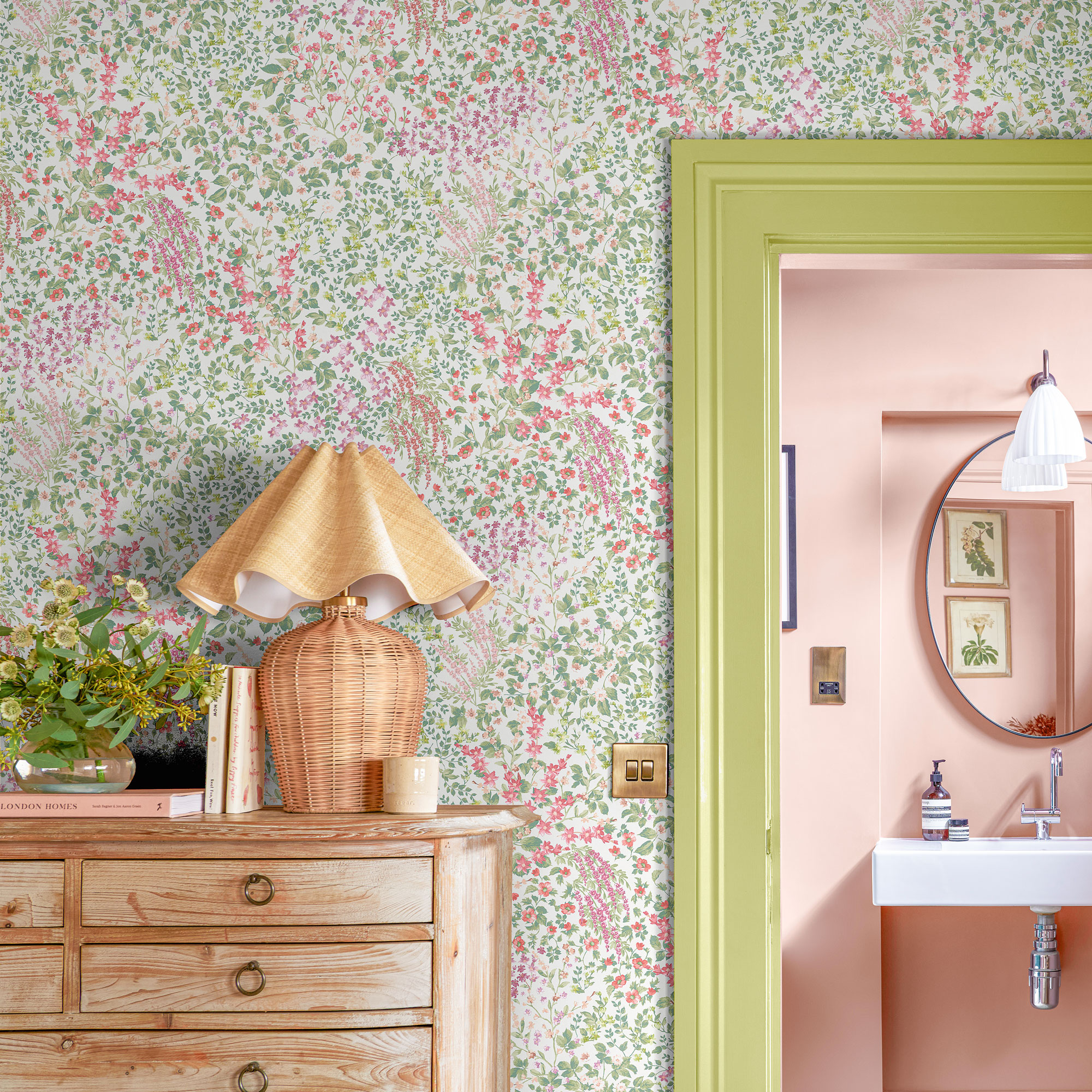 Floral wallpaper with green door frame and a wooden chest of drawers