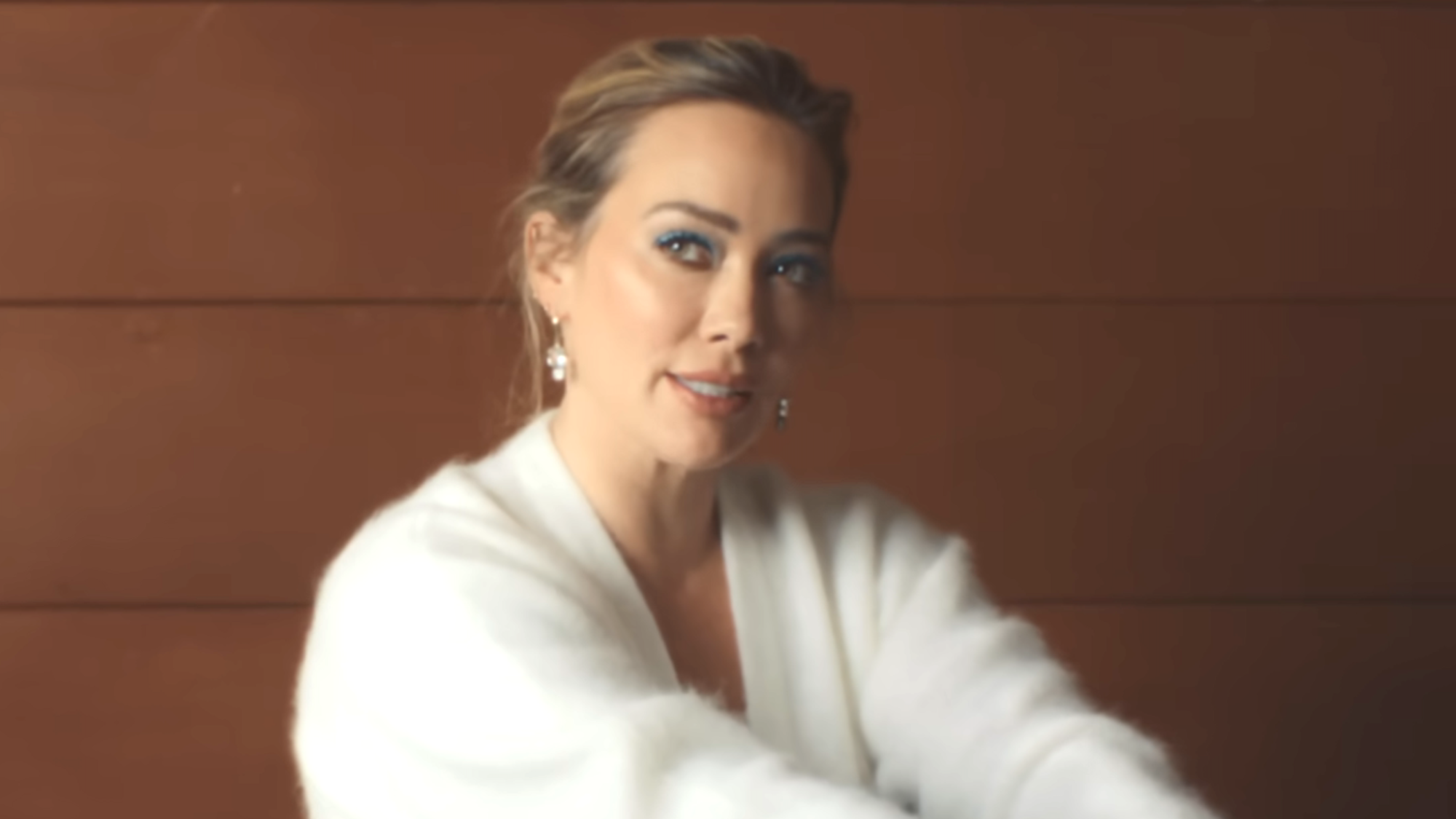 Hilary Duff in a white sweater in Weather For Tennis music video 