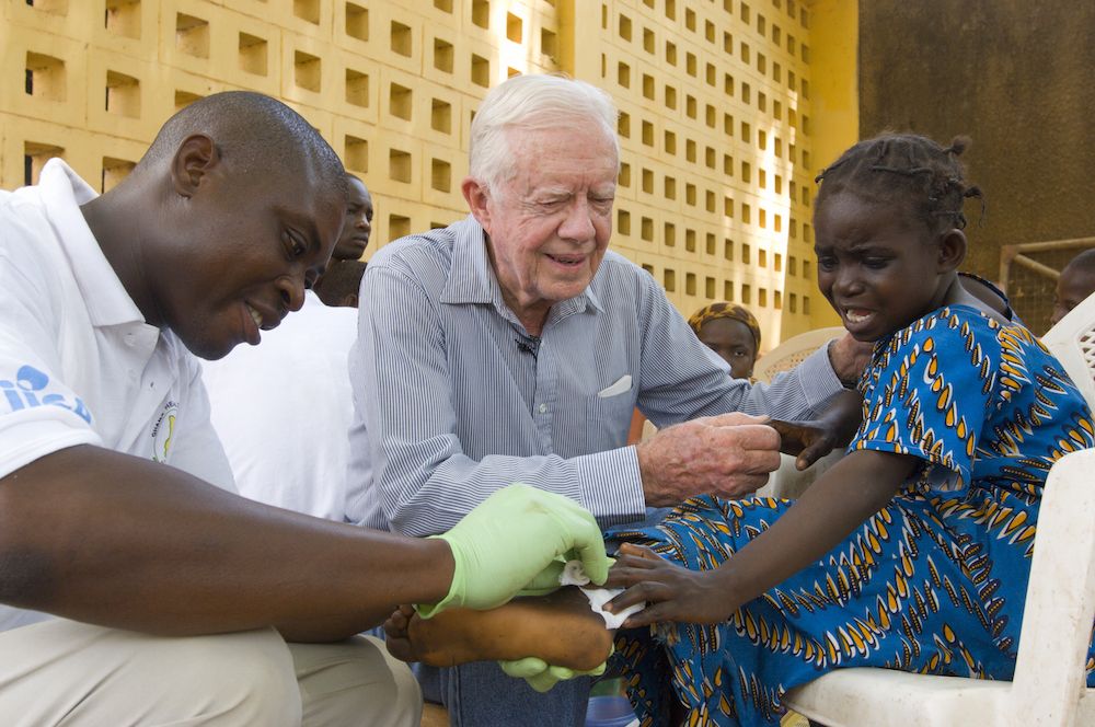 Jimmy Carter comforting girl who has Guinea worm.