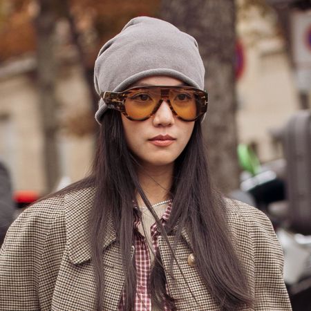 Yoyo Cao wears grey beanie, sunglasses, grey coat, - static hair