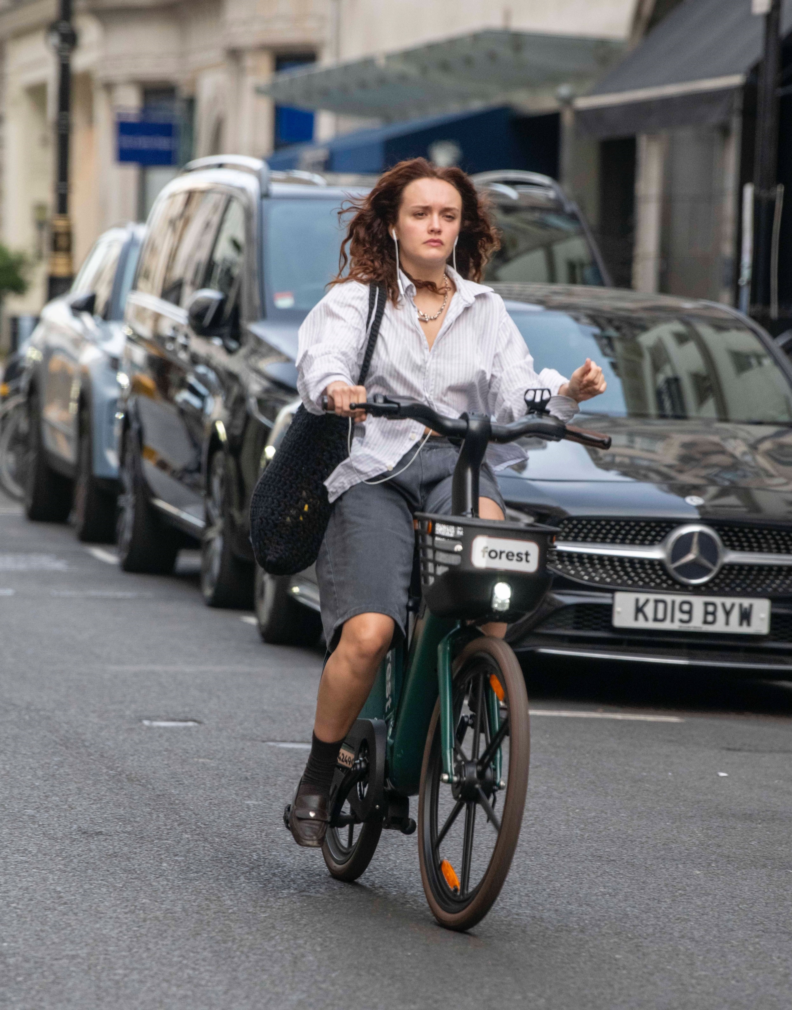 Olivia Cooke wore the Bermuda shorts trend and a button-down while riding a bike