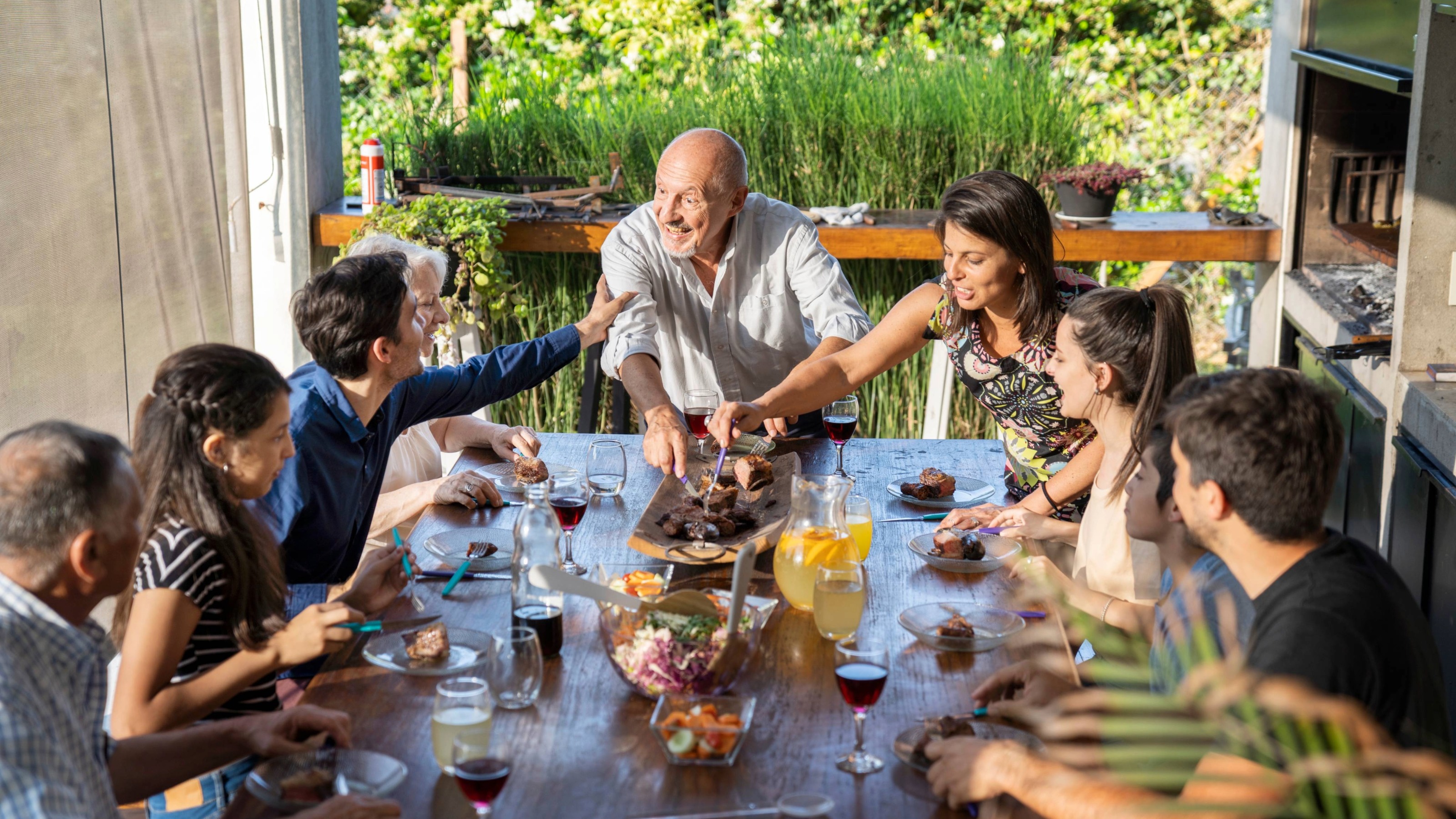 Multi-generation family having dinner party outdoors