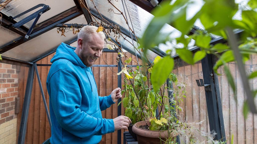 A smiling man in a greenhouse