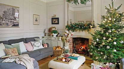 traditional-style living room with christmas tree and fire lit with grey corner sofa
