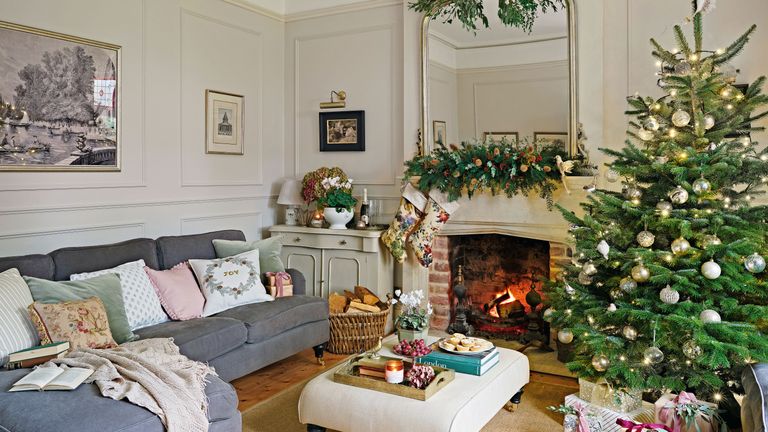 traditional-style living room with christmas tree and fire lit with grey corner sofa